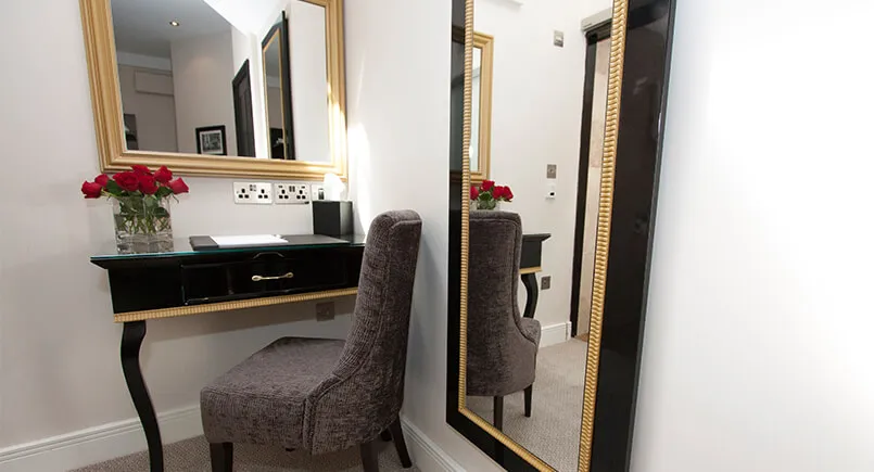 Black and gold hotel bedroom desk and mirror