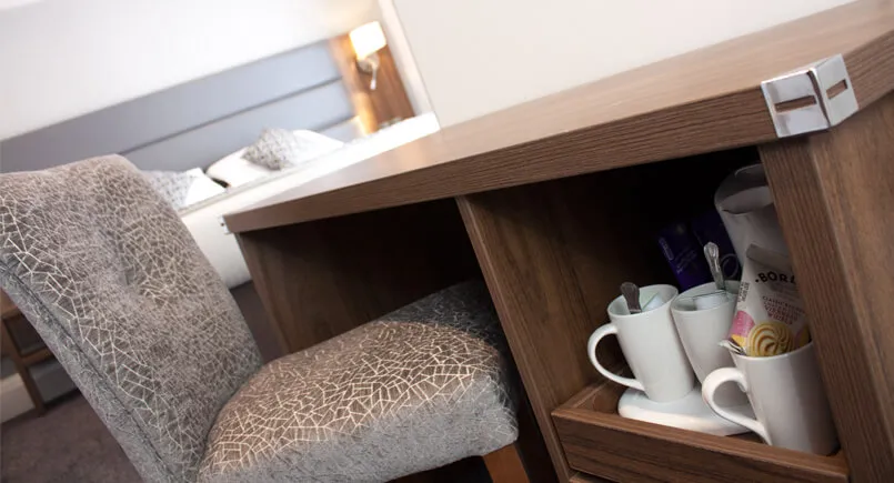Brown wooden hotel desk with pull out tea and coffee draw