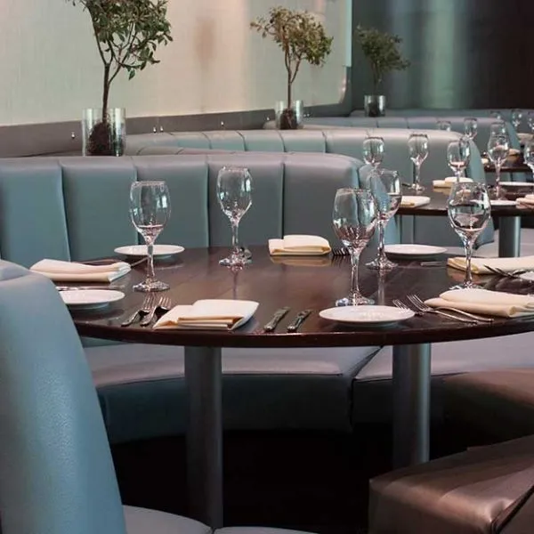 Curved banquette seating upholstered in soft green leather