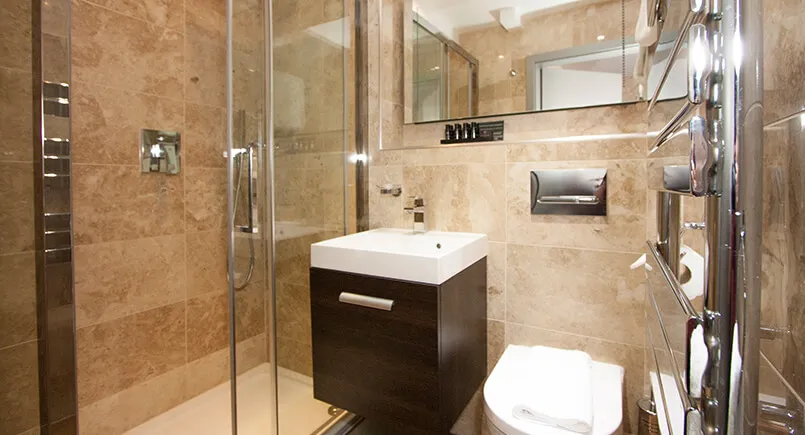 Hotel bathroom en-suite with dark wood cabinet